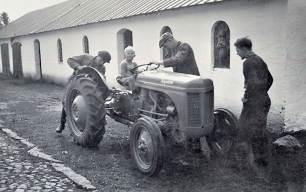 Søgaard får sin første traktor – en grå Ferguson 26 – i slutningen af 1940’erne, og lille Mogens Kronborg Brix sidder ved rattet. De populære Ferguson’er var en del af Marshall‐hjælpen fra USA til Europa i årene efter krigen.