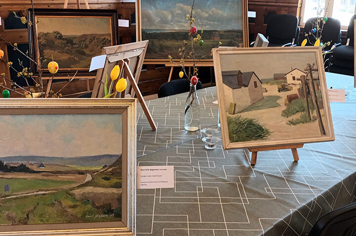 Malerier udstillet på et bord
